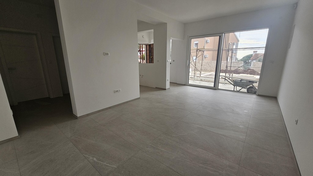 Séjour avec carrelage et porte coulissante vers la terrasse