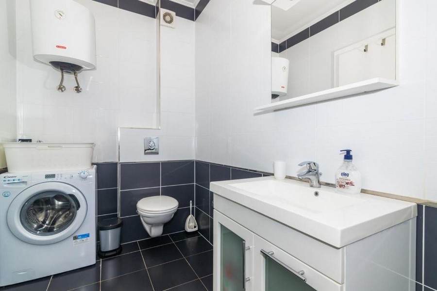 Salle de bains avec lavabo, WC et lave-linge