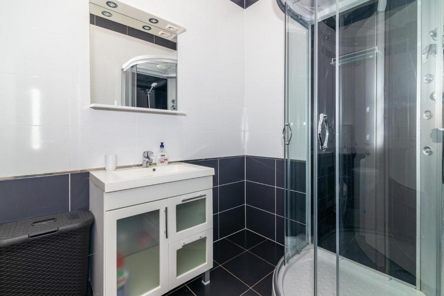 Salle de bains avec douche et cabine de douche en verre