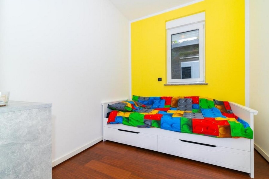 Deuxième chambre avec lit simple et mur coloré