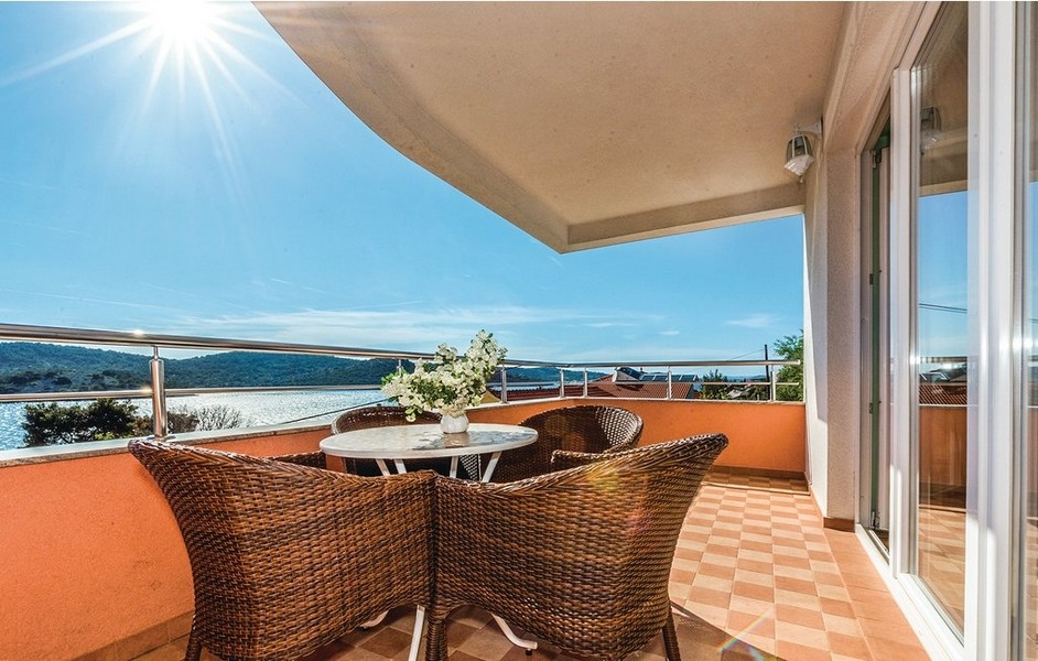 Terrasse couverte avec meubles en osier à contre-jour