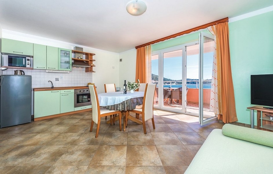 Cuisine-salle à manger vert menthe avec table à manger devant la porte du balcon
