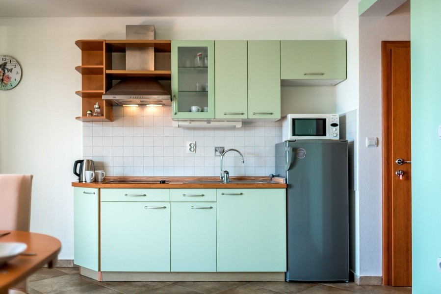 Cuisine linéaire vert menthe avec plan de travail en bois