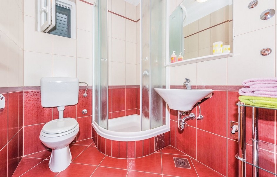 Salle de bains rouge et blanche avec cabine de douche ronde