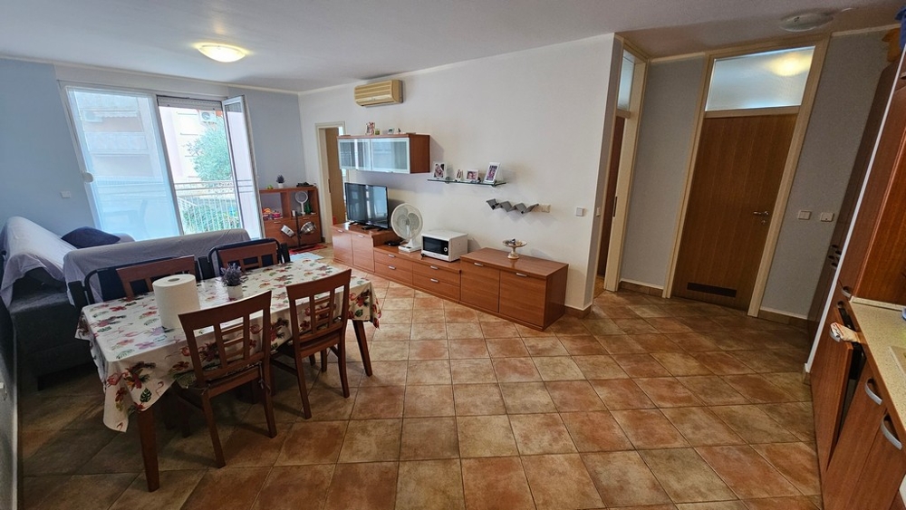 Séjour et coin repas avec cuisine ouverte et accès au balcon