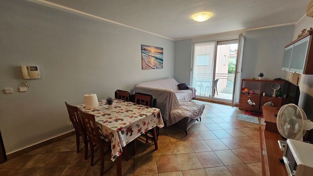 Salon avec canapé, coin repas et accès à la terrasse