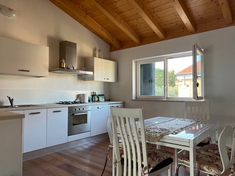 Cuisine avec coin repas et plafond à poutres en bois apparentes