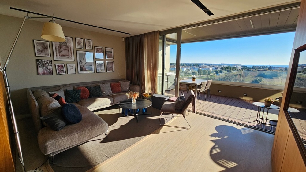 Salon avec grande façade vitrée et vue mer