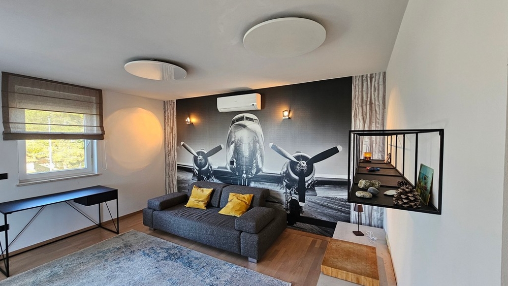 Salon avec canapé et motif mural dans un appartement à Novigrad