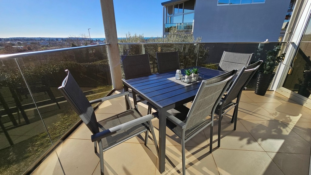 Terrasse couverte avec vue mer et salon de jardin
