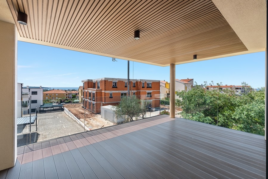 Loggia avec plafond en bois et vue sur le village jusqu'à la mer