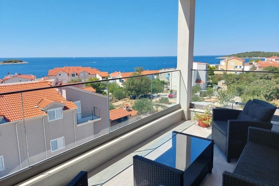 Balcon couvert avec mobilier lounge et vue panoramique sur la mer