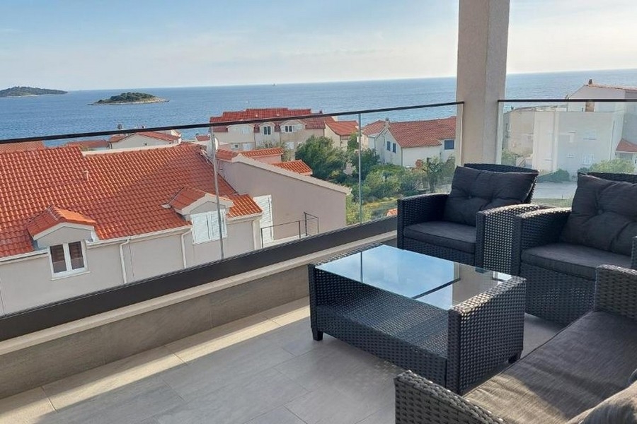 Balcon avec salon de jardin et vue sur le littoral et l'île au large