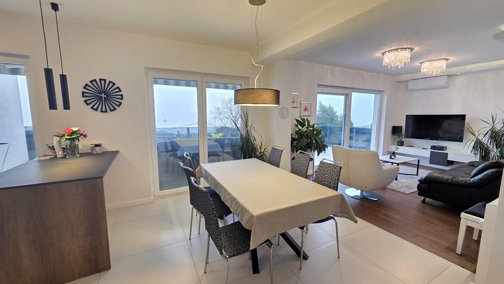 Coin repas avec porte de la terrasse et séjour ouvert