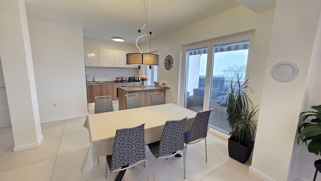Table à manger avec six chaises devant la cuisine linéaire