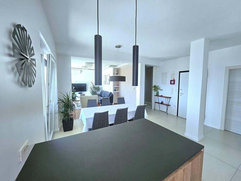 Comptoir de cuisine avec vue sur le coin repas et le couloir d'entrée