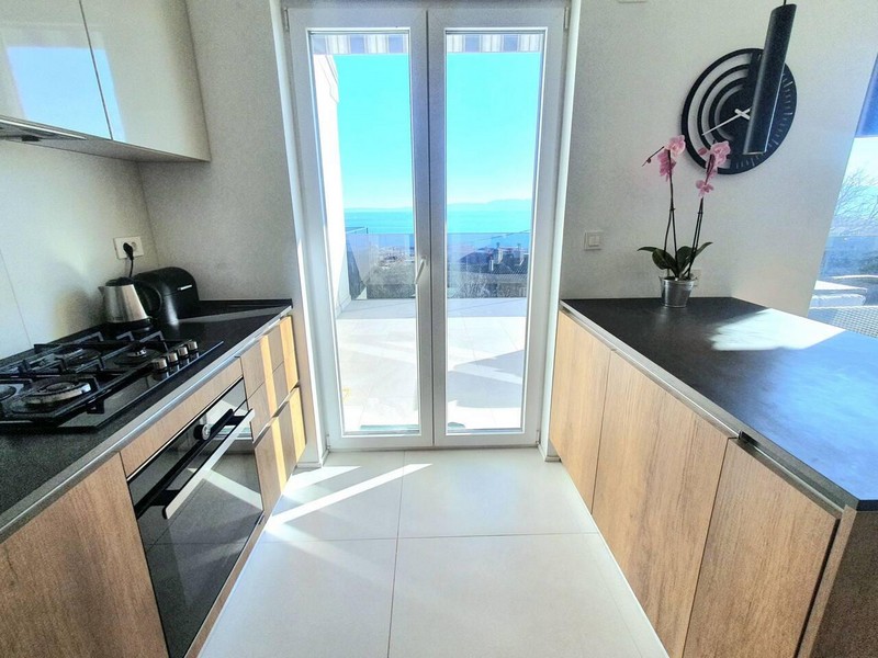 Cuisine avec orchidée et porte de la terrasse donnant sur la mer