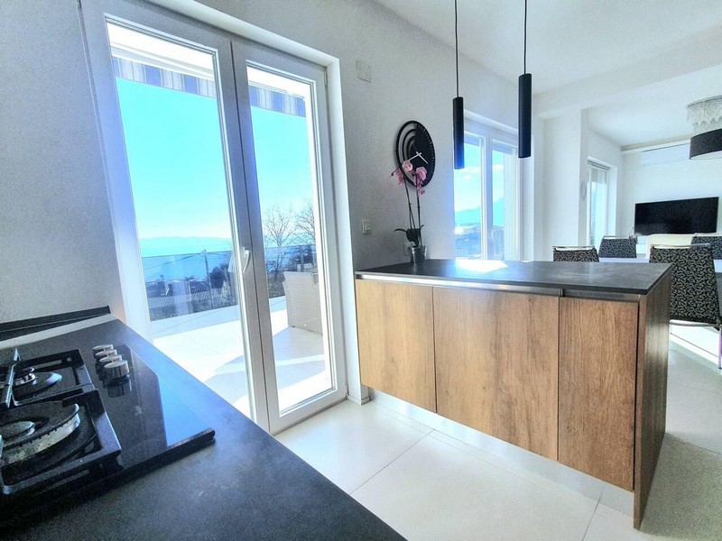 Cuisine avec plaque de cuisson et vue par la porte sur la terrasse