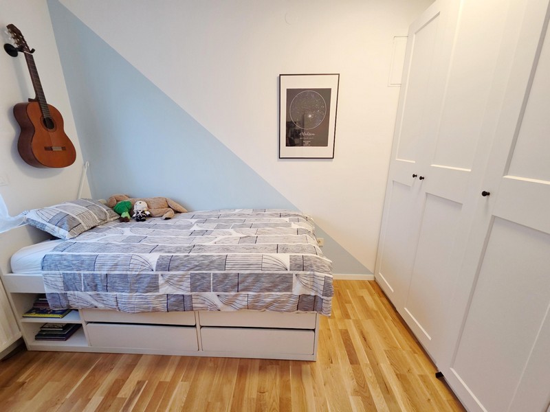 Chambre d'enfant avec lit, guitare et penderie