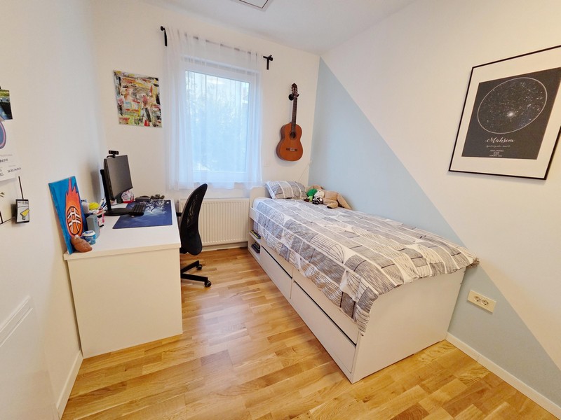 Chambre d'adolescent avec bureau, lit et guitare au mur