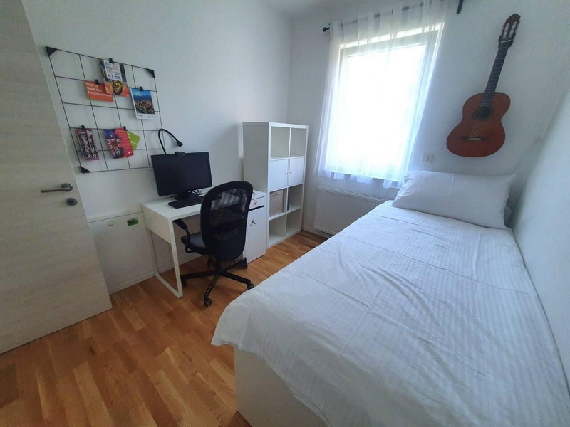 Pièce avec lit simple, bureau et étagère