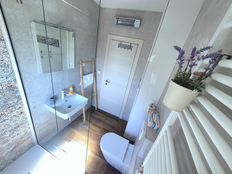 Salle de bains avec douche en verre et radiateur sèche-serviettes