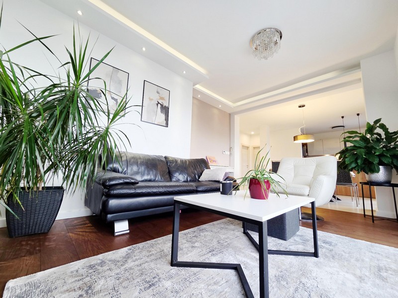 Séjour avec table basse, plantes d'intérieur et lustre en cristal
