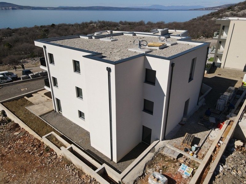 Immeuble collectif neuf à toit plat et architecture moderne près de la côte