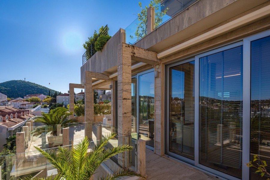 Terrasse moderne avec garde-corps en verre et vue mer