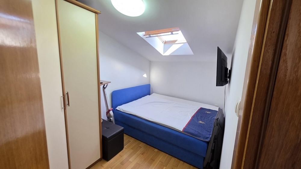 Chambre avec fenêtre de toit et lit simple