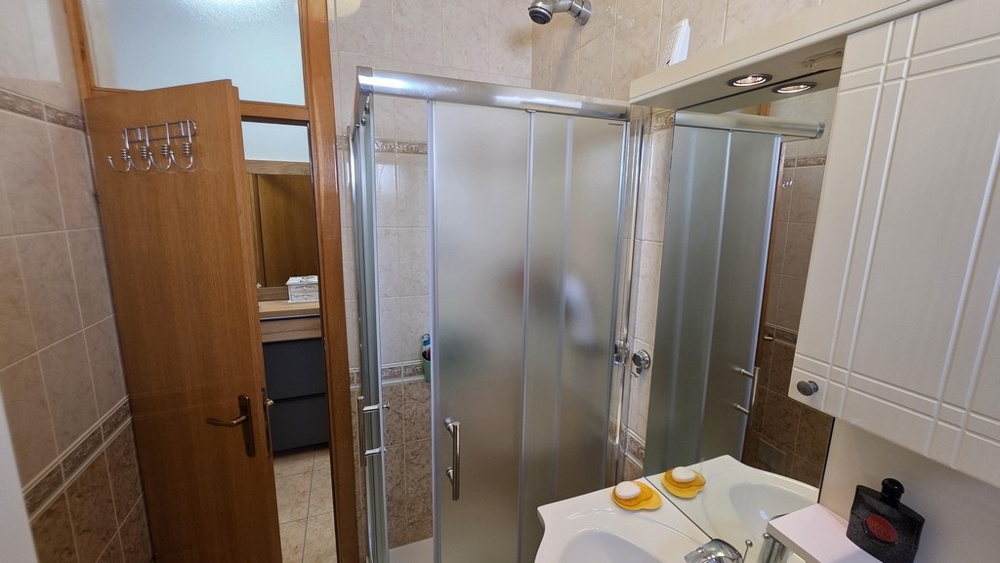 Salle de bains avec cabine de douche et lavabo