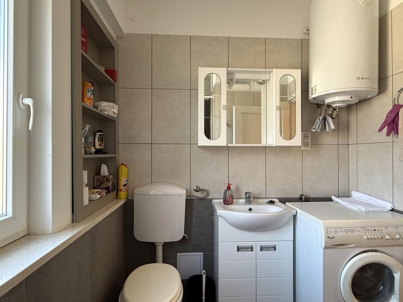 Salle de bains avec lave-linge et lavabo