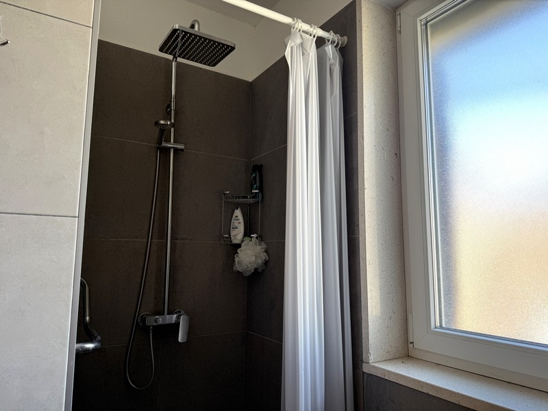 Salle de bains avec douche et fenêtre
