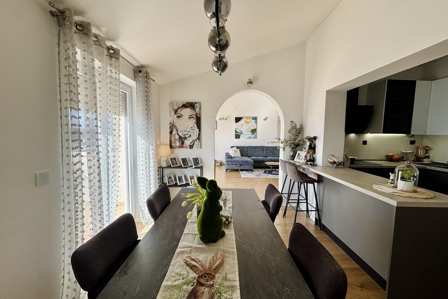 Coin repas ouvert avec accès à la cuisine et beaucoup de lumière du jour