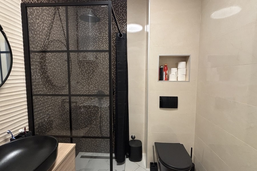 Salle de bains avec douche et robinetterie noire
