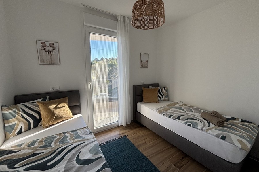 Chambre avec deux lits simples et accès au balcon