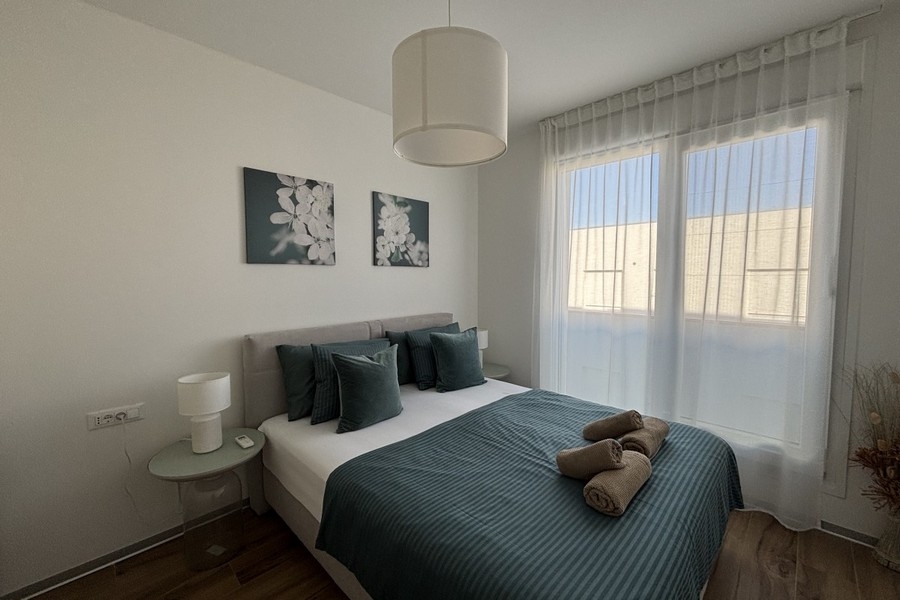 Chambre avec lit double et grandes fenêtres