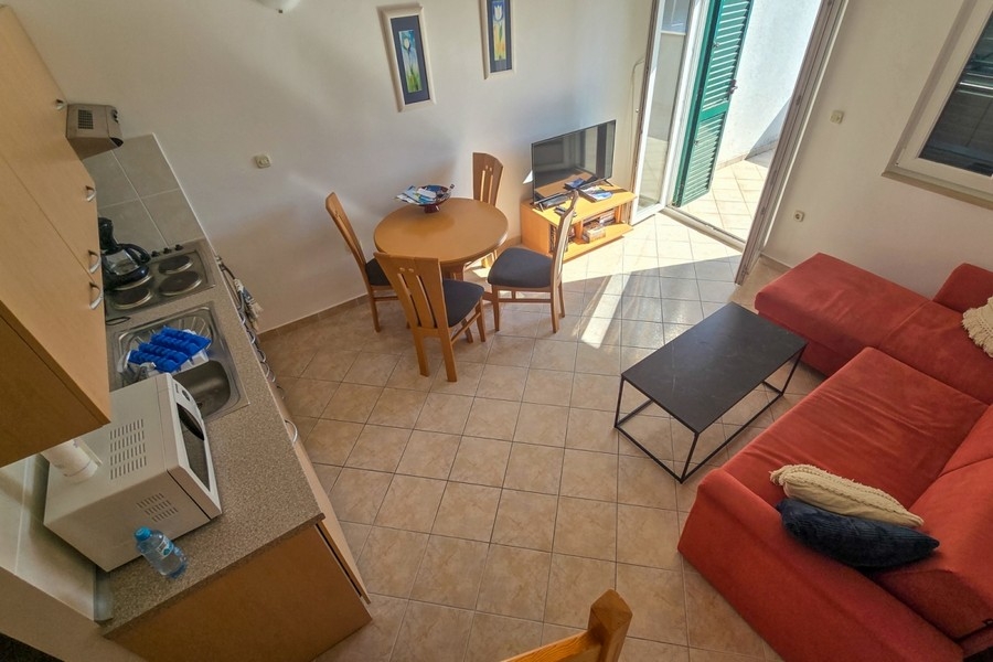 Séjour lumineux avec cuisine ouverte et accès au balcon