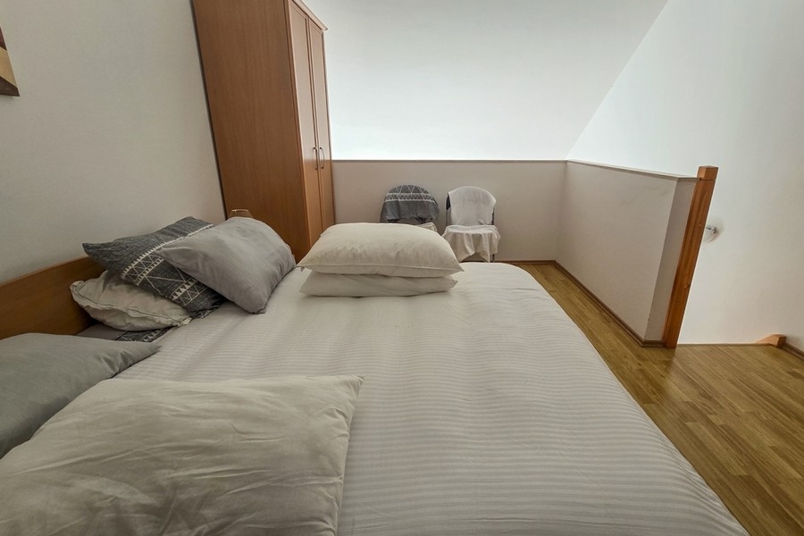 Coin nuit sur la mezzanine avec lit double et armoire