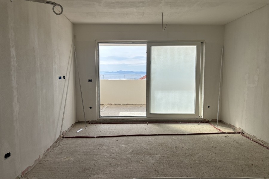 Séjour ouvert avec grandes portes coulissantes et vue sur la mer