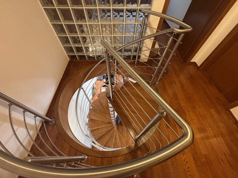 Escalier en colimaçon moderne avec marches en bois et rampe en inox