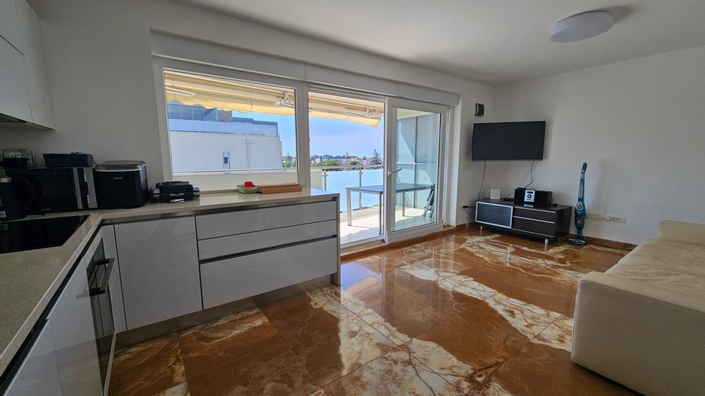 Séjour avec cuisine et accès au balcon avec vue mer