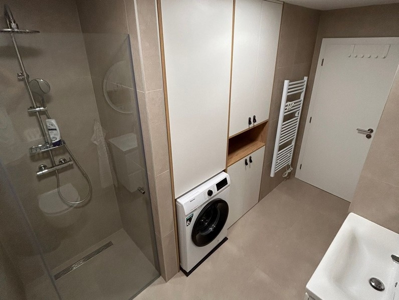Salle de bains avec douche, lave-linge et placard intégré
