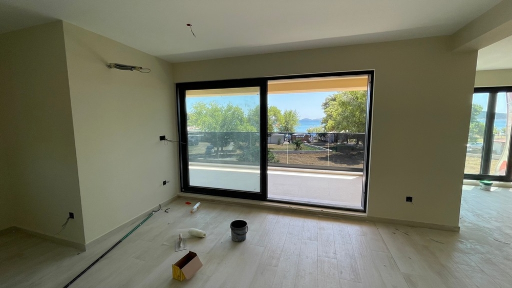 Pièce avec baie vitrée, accès au balcon et vue mer