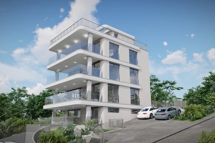 Immeuble neuf avec grands balcons et garde-corps en verre sur terrain en pente