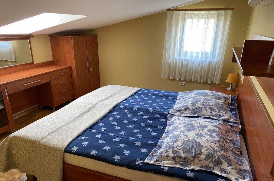 Chambre avec lit double et fenêtre de toit dans un appartement sur Krk