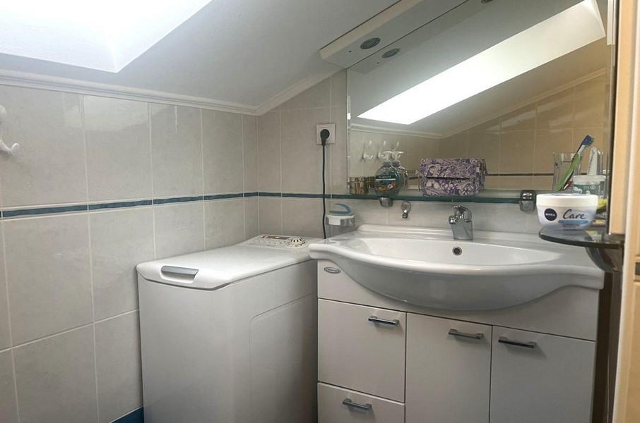Salle de bains avec lave-linge et lavabo