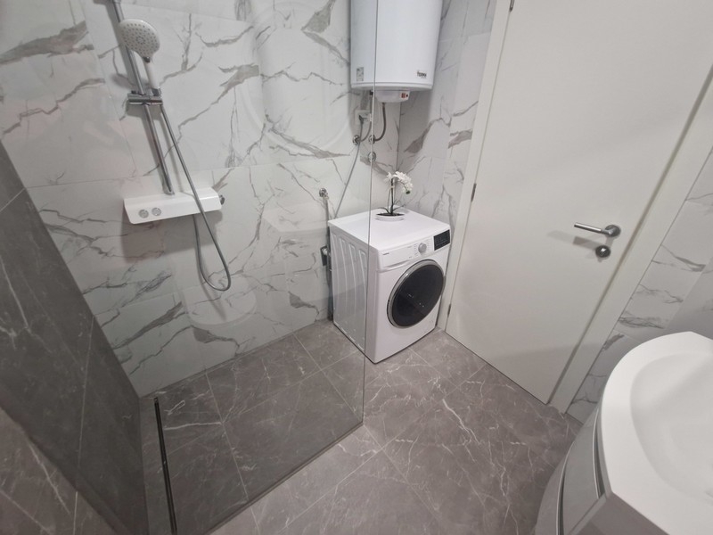 Salle de bains avec douche à l'italienne et lave-linge