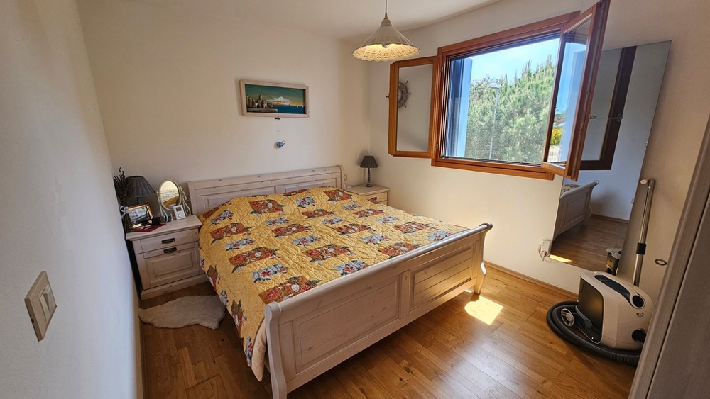 Chambre avec parquet en bois et fenêtre