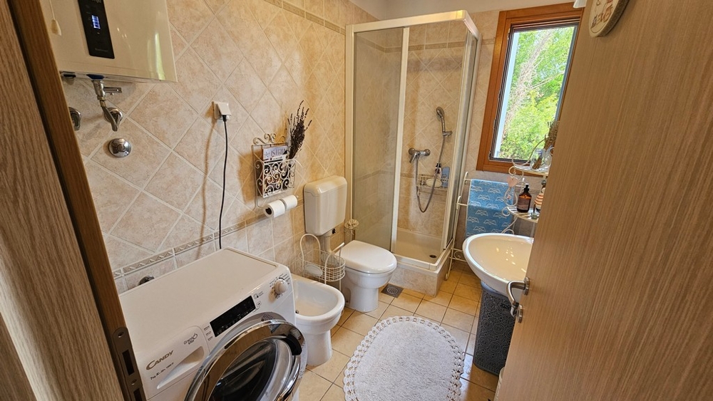 Salle de bains avec douche et lave-linge